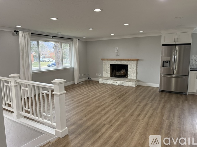 A living room with a fireplace and a refrigerator.