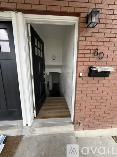 A black door is open to a hallway.