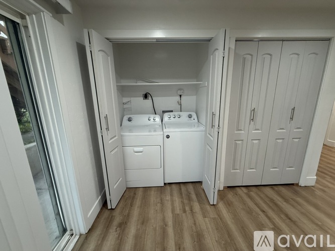 A small, white, compact kitchen with a sink and a stove top.