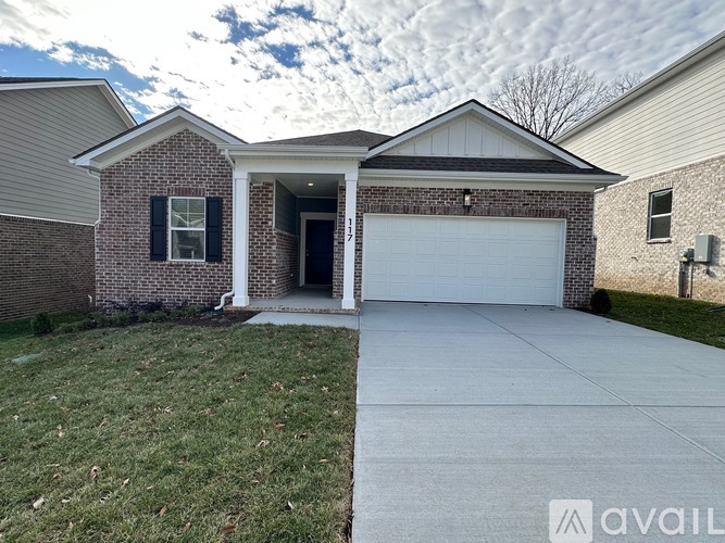 A house with a garage and a driveway in front.