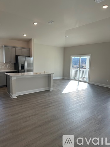 A spacious kitchen with a refrigerator, microwave, and oven.