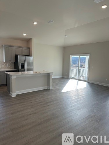 A spacious kitchen with a refrigerator, microwave, and oven.