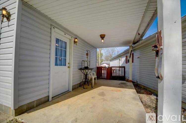 A porch with a white door and a lamp on the left.