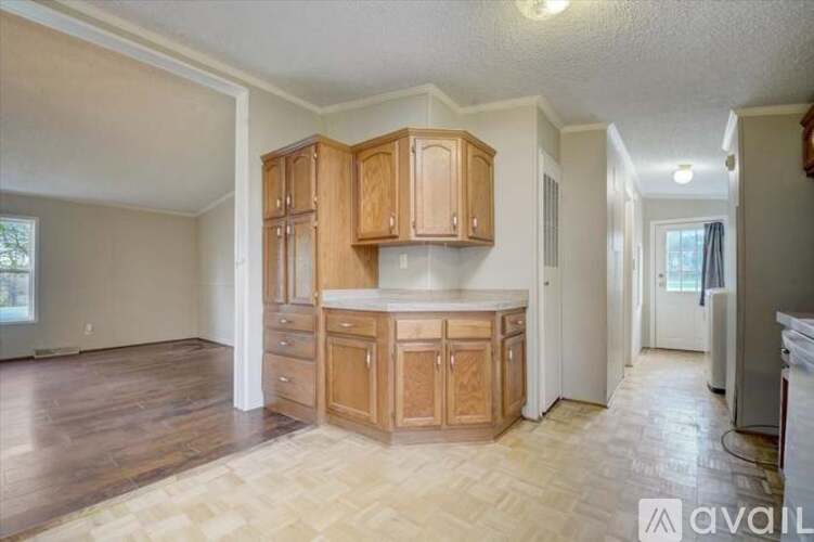 A kitchen with wooden cabinets and a countertop is available for rent.