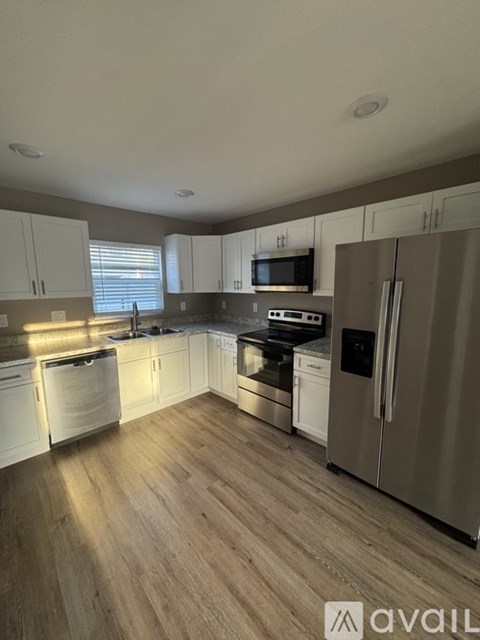 A kitchen with white cabinets and stainless steel appliances.