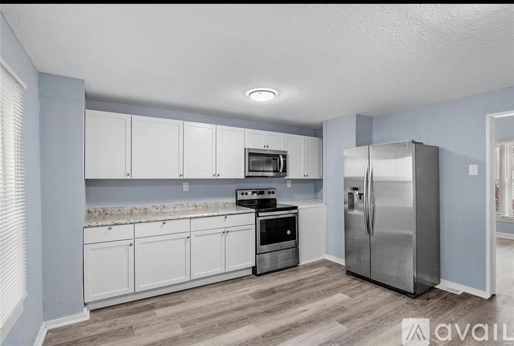 A kitchen with white cabinets and stainless steel appliances.