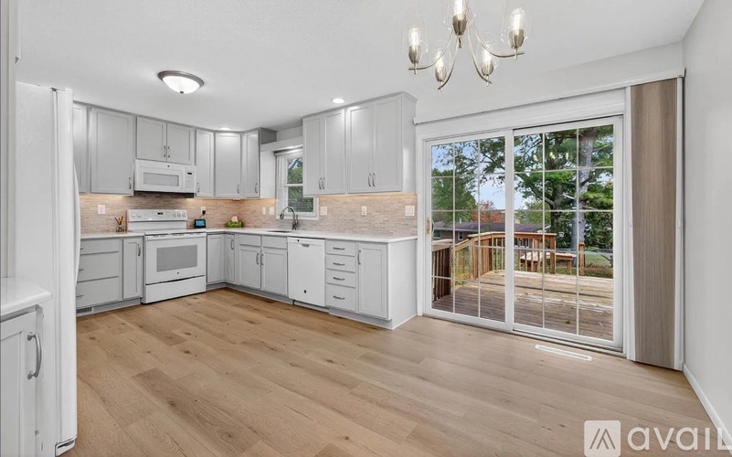 A kitchen with white cabinets and a wooden floor.