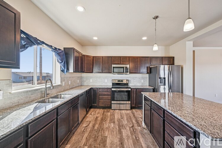 A kitchen with dark wood cabinets and granite countertops.