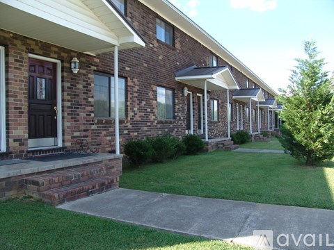 A row of houses with a grassy front yard.