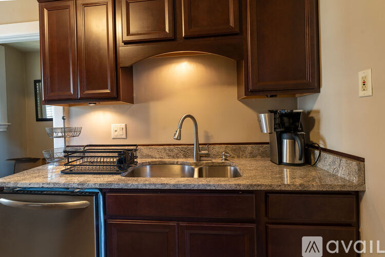 A kitchen with brown cabinets and a granite countertop.