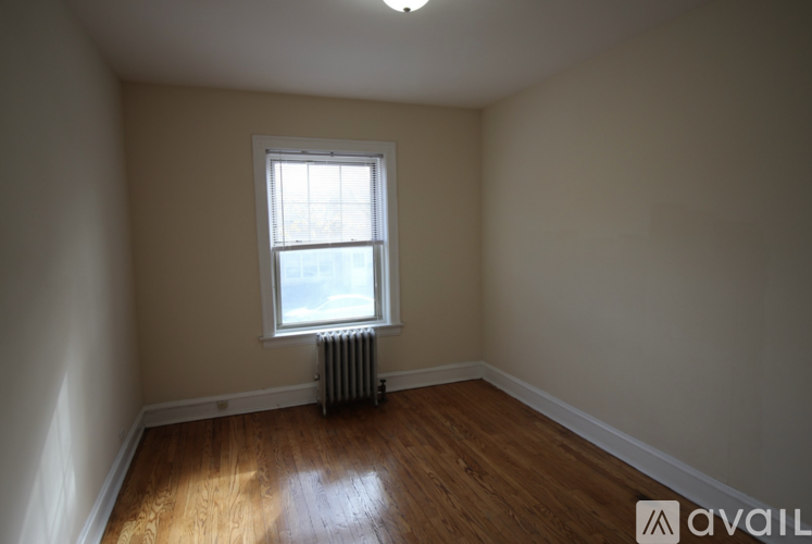 A room with a window and a radiator on the floor.