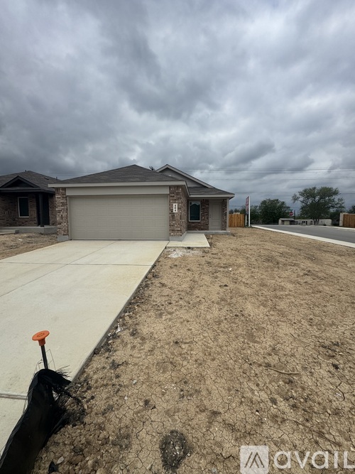 A house with a grey garage door and a brown roof is shown.