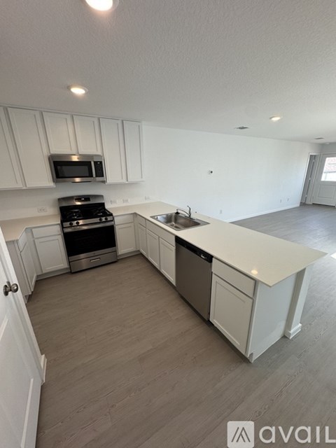 A kitchen with white cabinets and a microwave above the stove.