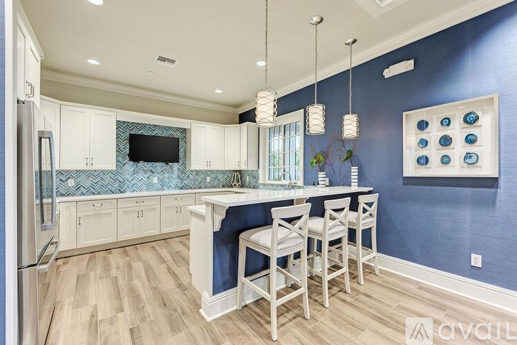 A kitchen with white cabinets and a blue backsplash.