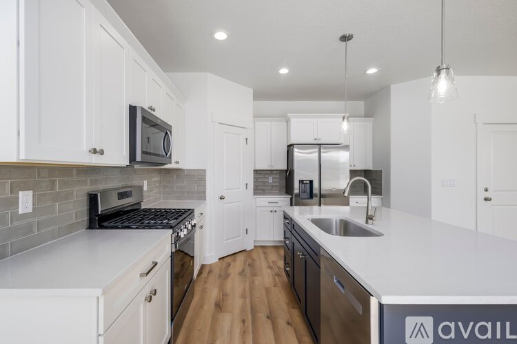 A kitchen with white cabinets and a black stove top oven.