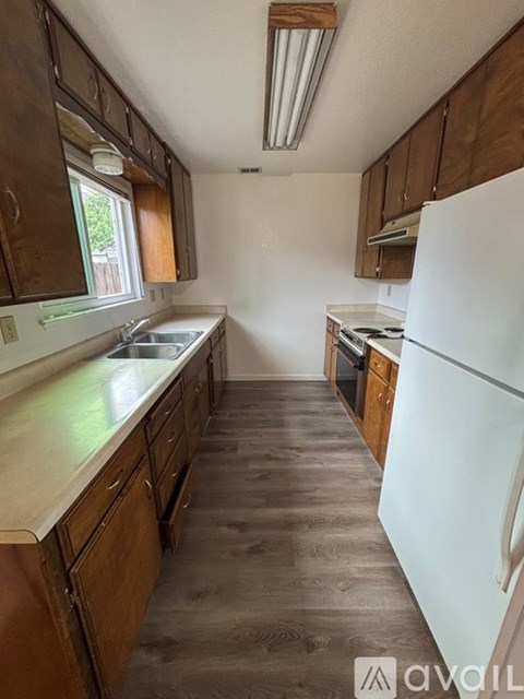 A kitchen with wooden cabinets and a white fridge.