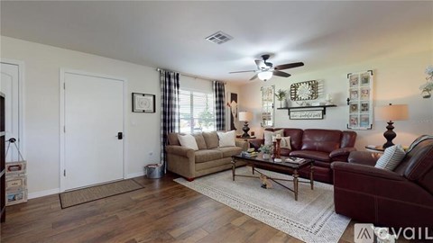 A living room with a brown leather couch and a beige couch.