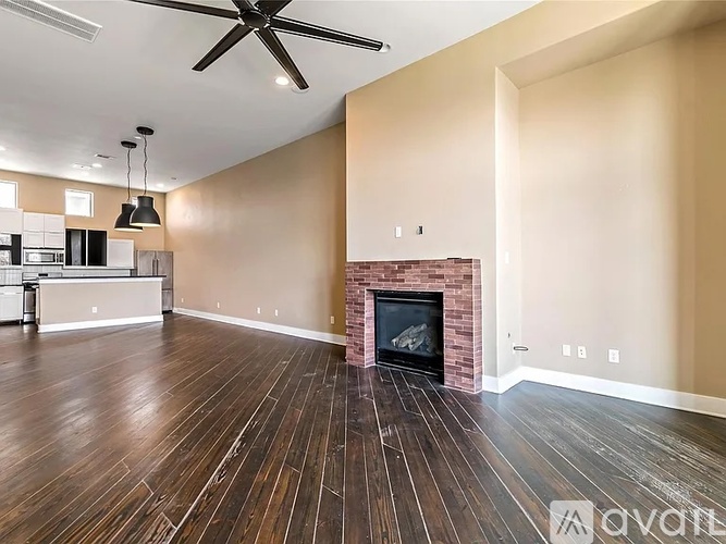A spacious living room with a fireplace and hardwood floors.