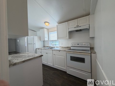 A kitchen with white cabinets and a marble countertop.