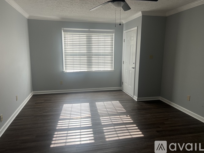 A room with a ceiling fan and a window with blinds.