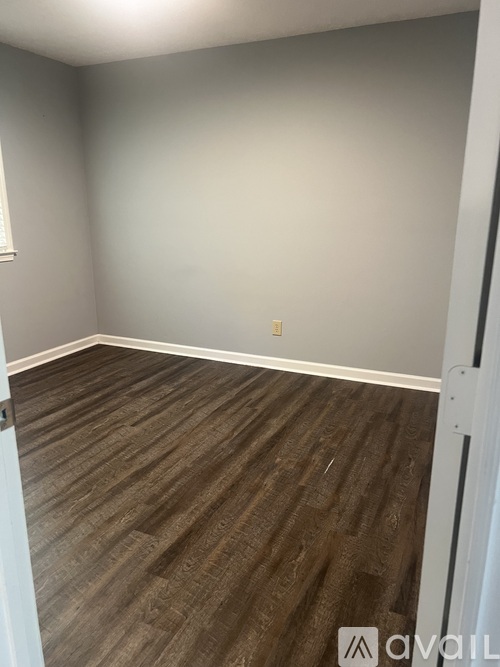 A room with wooden flooring and a white door.