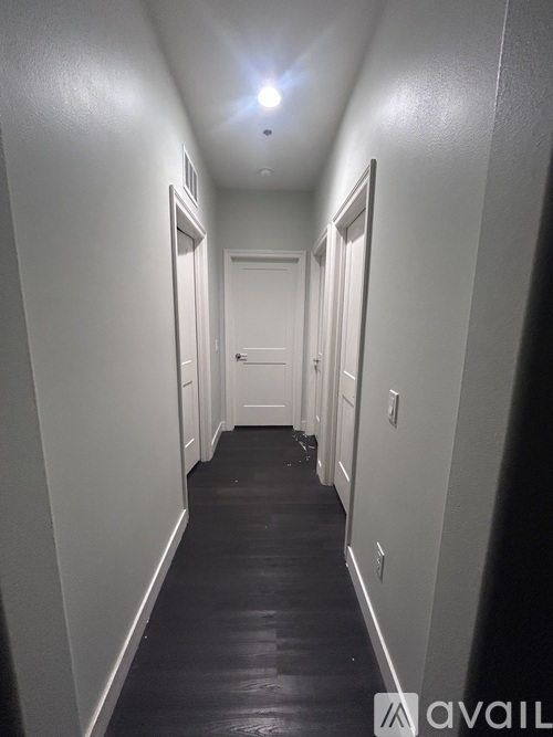 A long hallway with doors on both sides and a light on the ceiling.