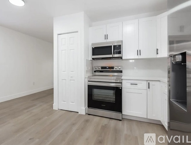 A kitchen with white cabinets and stainless steel appliances.