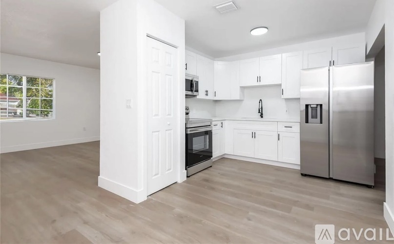 A kitchen with white cabinets and stainless steel appliances.