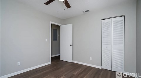 A room with a ceiling fan and a door.