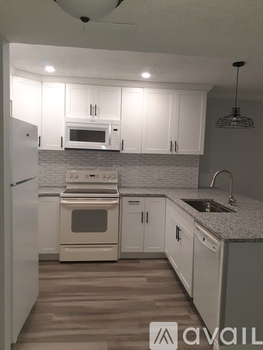 A kitchen with white cabinets and appliances.