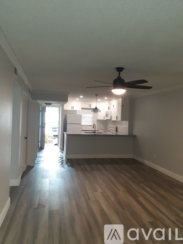 A room with a ceiling fan and wooden flooring.