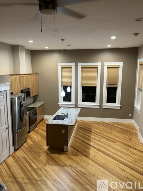 A kitchen with wooden floors and a central island.