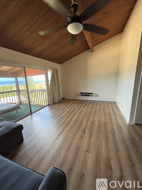 A living room with wooden floors and a ceiling fan.