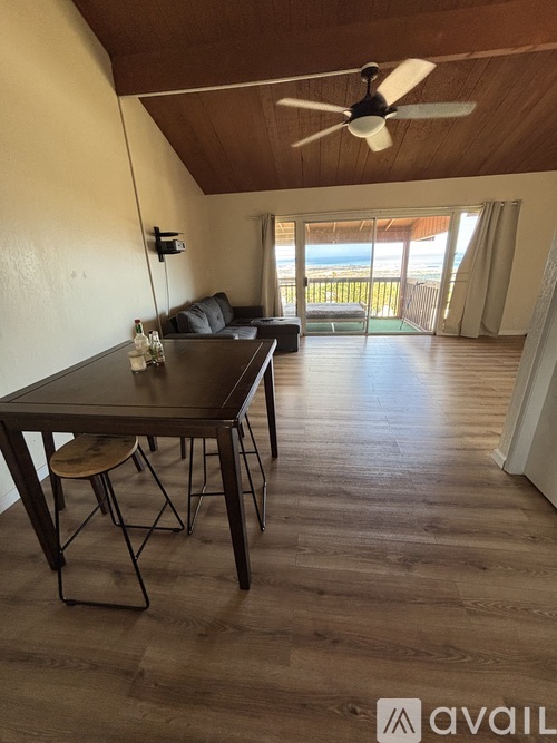 A dining room with a table and chairs and a ceiling fan.