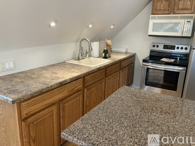 A kitchen with granite countertops and wooden cabinets.