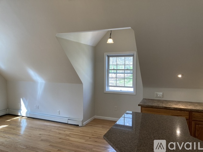 A room with a window and a countertop is available for rent.