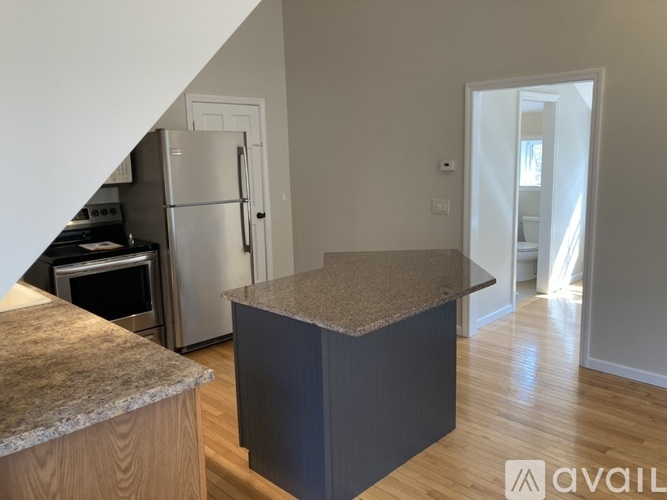 A kitchen with a granite countertop and a refrigerator.
