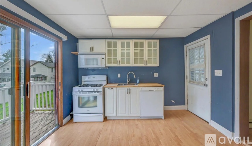A kitchen with blue walls and wooden floors.