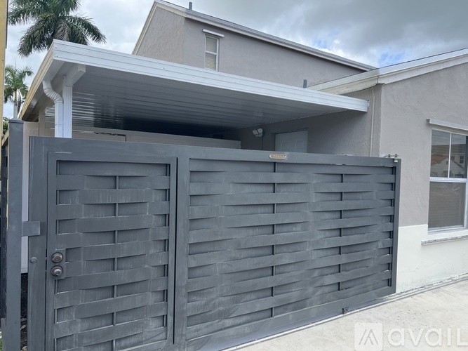 A black gate is in front of a house.