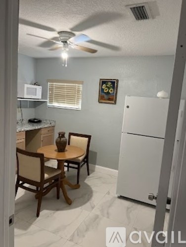 A kitchen with a table and chairs.