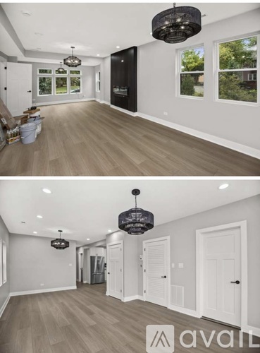 A modern living room with a large chandelier and a hallway with white doors.