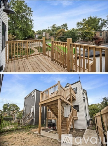 A wooden deck with a railing and stairs leading to a house.