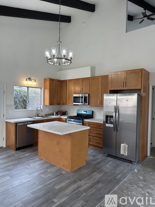 A kitchen with wooden cabinets and a white island.