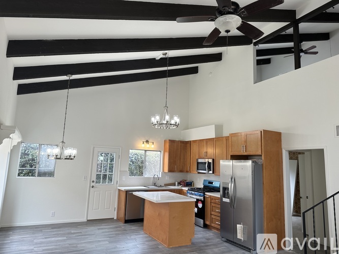 A modern kitchen with wooden cabinets and a large island.
