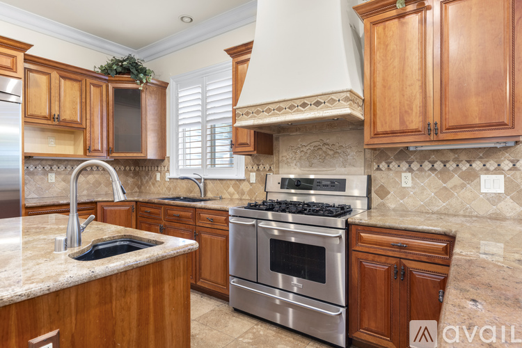 A kitchen with wooden cabinets and a stainless steel oven.