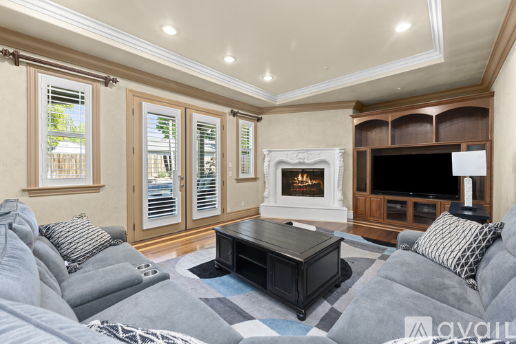 A living room with a grey sofa and a black coffee table.