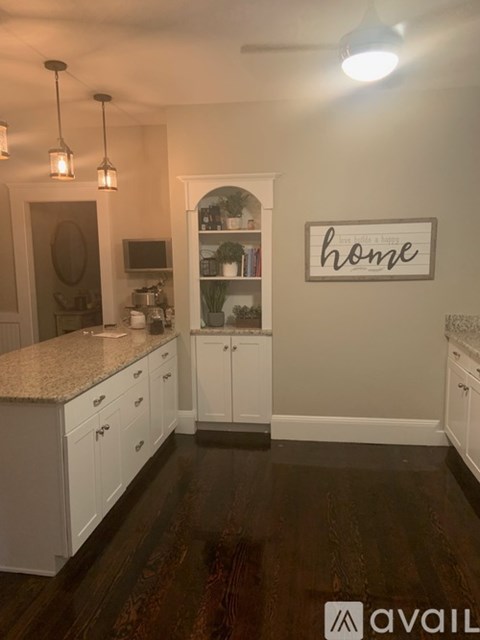 A kitchen with white cabinets and a granite countertop.