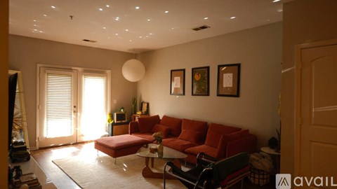 A living room with a red couch and a white ceiling.
