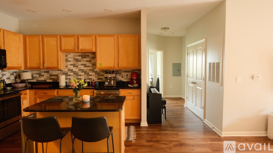 A kitchen with wooden cabinets and a black fridge.