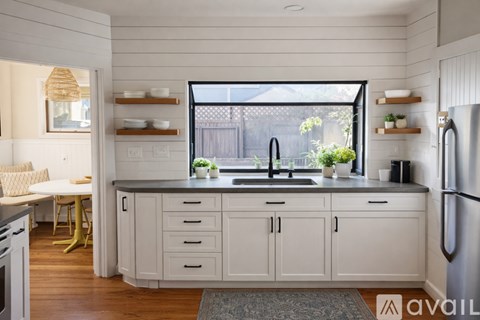 A kitchen with white cabinets and a black sink.